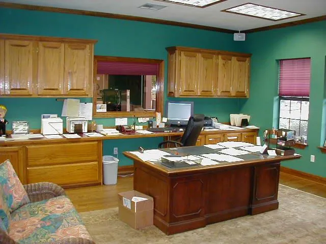 Front manager/owner’s office with wood cabinetry and desk